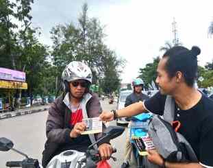 Ketgam :  Anggota join bersama  KJ3 saat membagikan stiker Anti Hoax di perempatan lampu merah Mtq