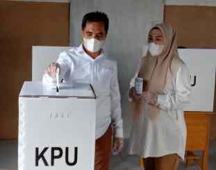 H.Raup S.Ag MM bersama istri saat menyalurkan hak pilihnya